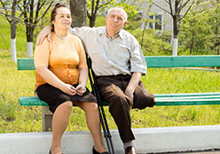 Two adults sitting on a bench.